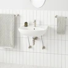 a white sink sitting under a bathroom mirror next to a wall mounted faucet