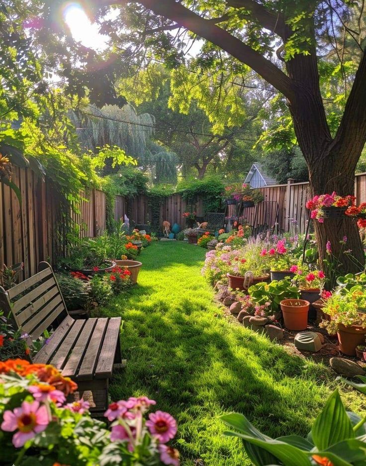 a wooden bench sitting in the middle of a lush green yard next to a tree