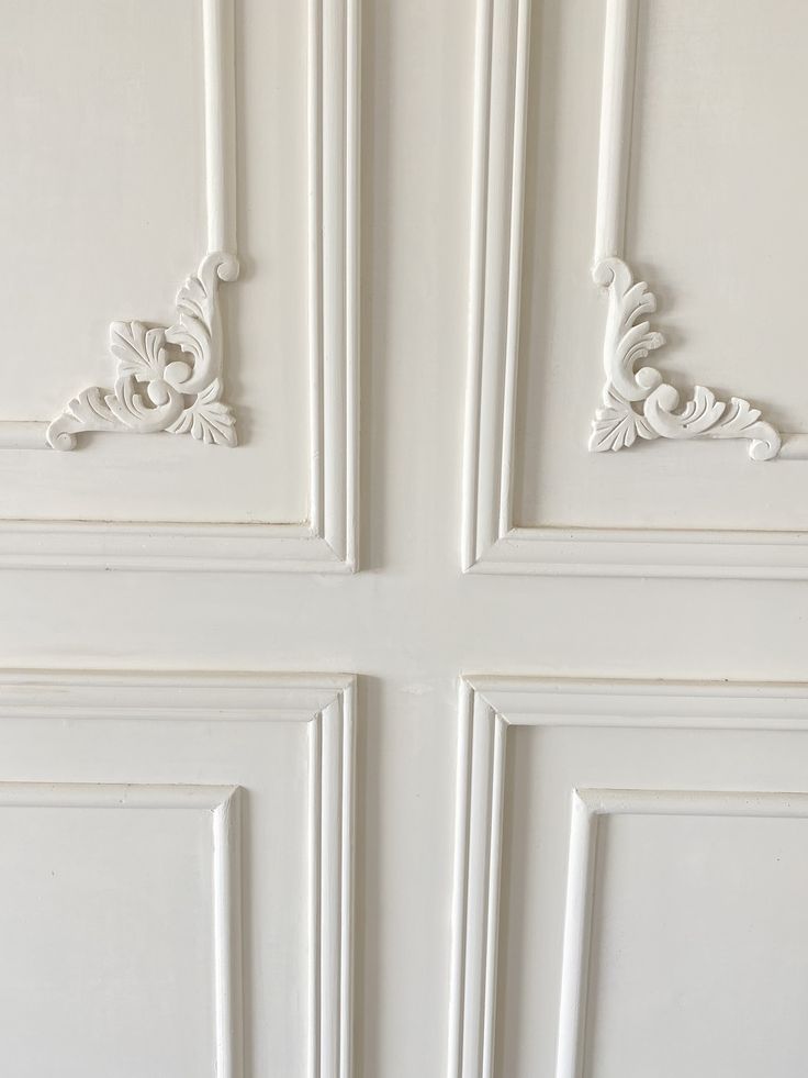 the door is painted white and has ornate carvings on it's side paneling