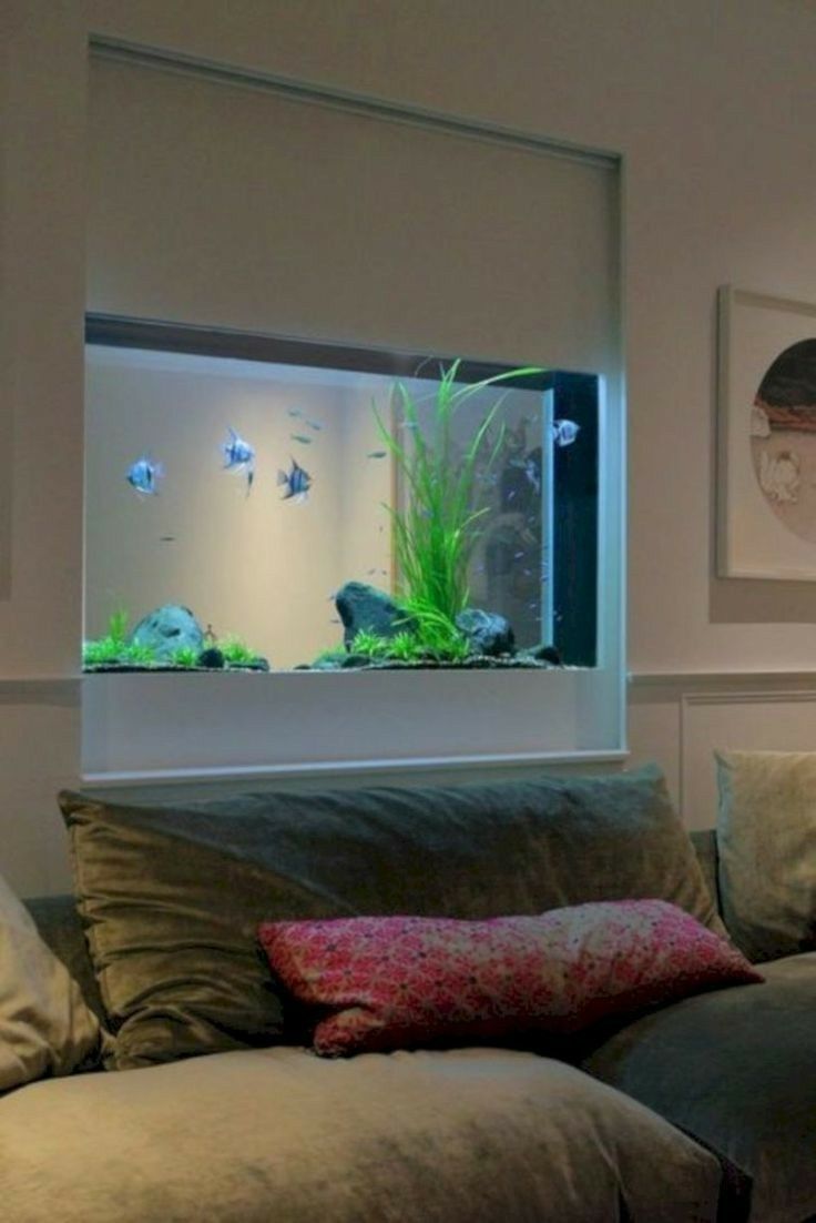 a living room filled with furniture and a fish tank in the window sill above it