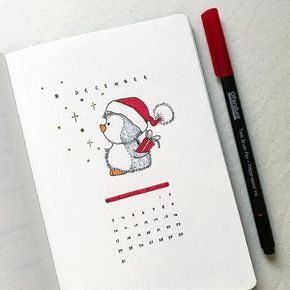 an open notebook with a penguin wearing a santa hat and holding a red pen next to it