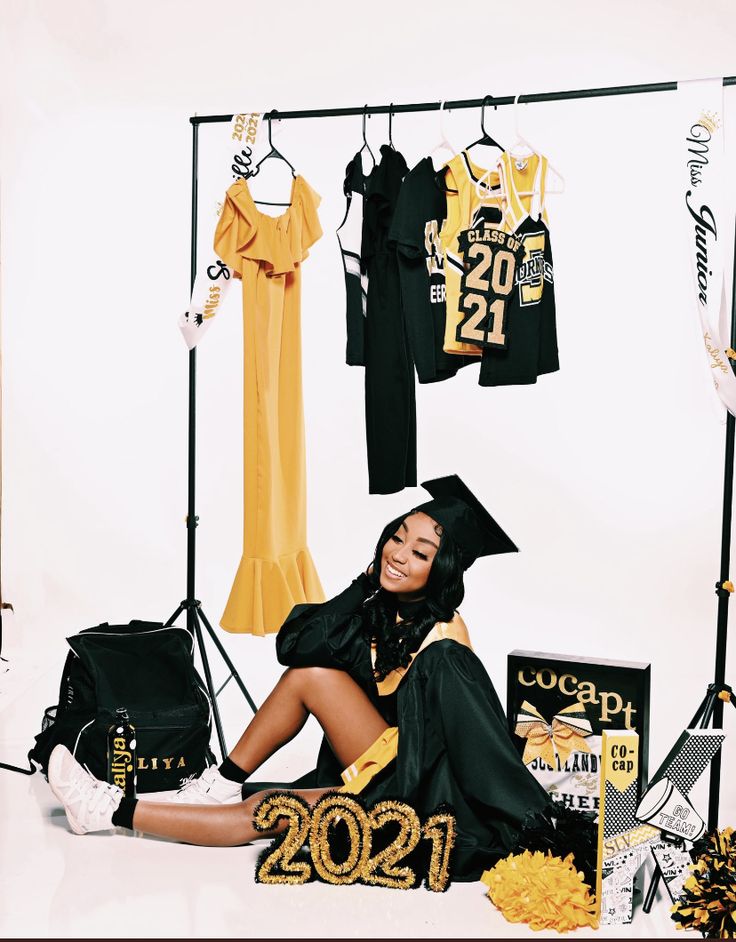 a woman sitting on the floor in front of graduation decorations