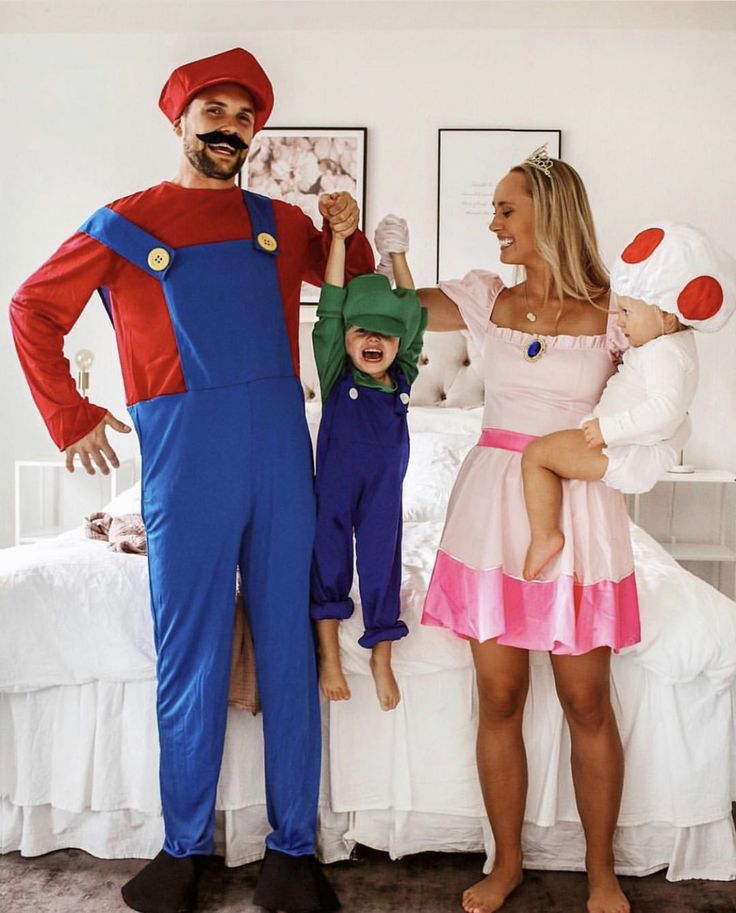 a man and woman are dressed up as mario and princess peaches with their child