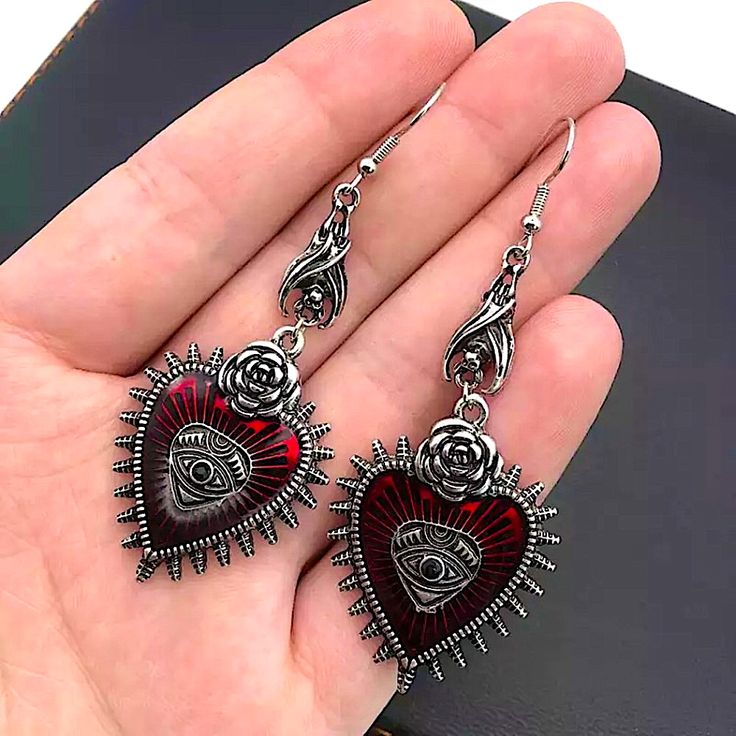 Brand New Boutique Item. Pair Of Red & Silver Metal Gothic Style Dangle Earrings That Feature Read Hearts With Spikes & A Silver Rose On Top, An Evil Eye In The Middle, & A Little Bat Hanging Upside Down From The Top Of Each Earring. See Pictures For Details. Tags: Goth Symbols Vampire Bat Jewelry Heart-shaped Alloy Earrings For Party, Heart-shaped Alloy Jewelry For Pierced Ears, Red Alloy Jewelry For Party, Silver Gothic Earrings For Valentine's Day, Valentine's Day Heart-shaped Alloy Earrings, Valentine's Day Party Earrings In Alloy, Valentine's Day Party Earrings Made Of Alloy, Elegant Heart Shaped Alloy Earrings, Elegant Heart-shaped Alloy Earrings