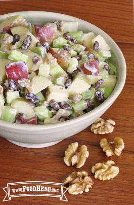 a bowl filled with fruit and nuts on top of a wooden table