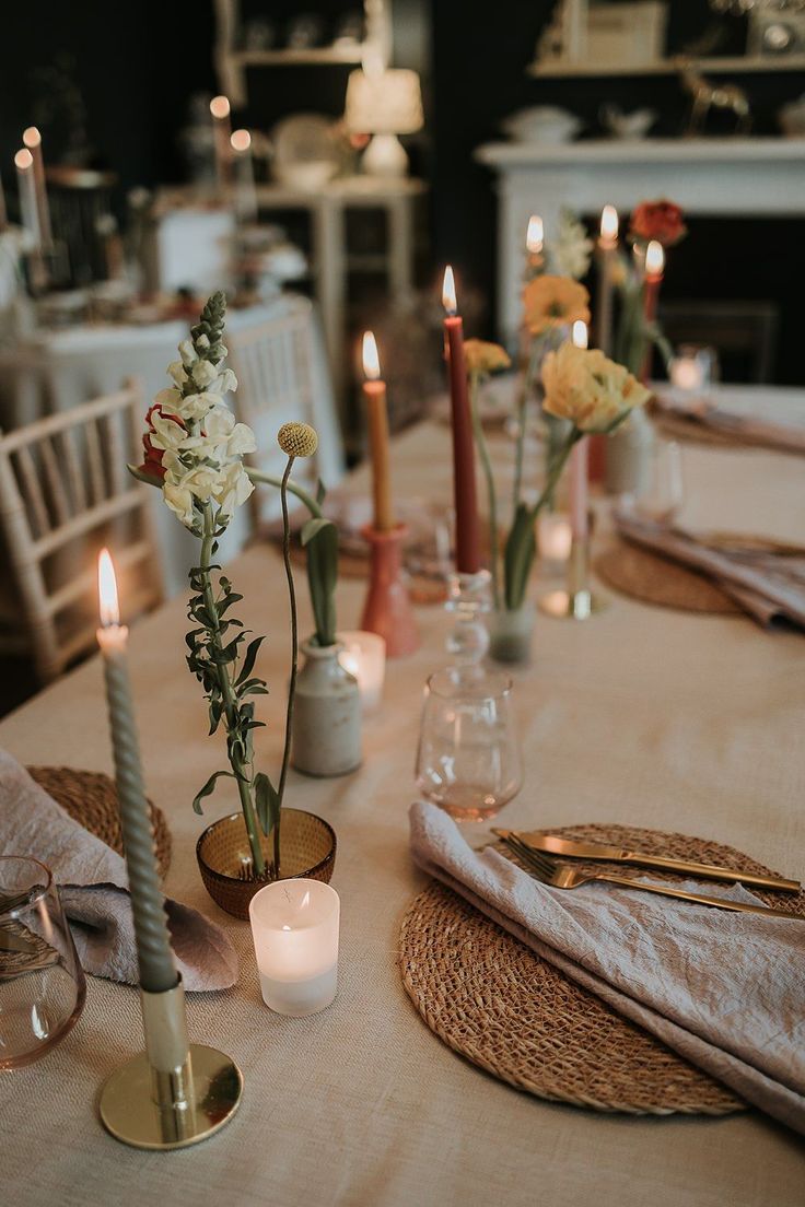 the table is set with candles, flowers and napkins for dinner guests to enjoy