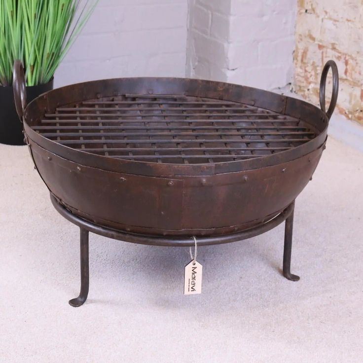 a grill sitting on top of a table next to a potted plant