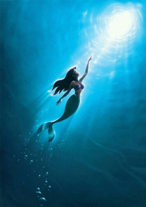 the little mermaid is swimming in the water