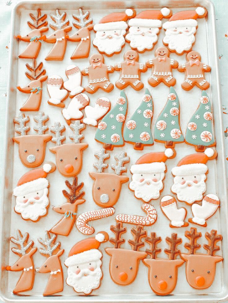 an assortment of decorated christmas cookies on a tray