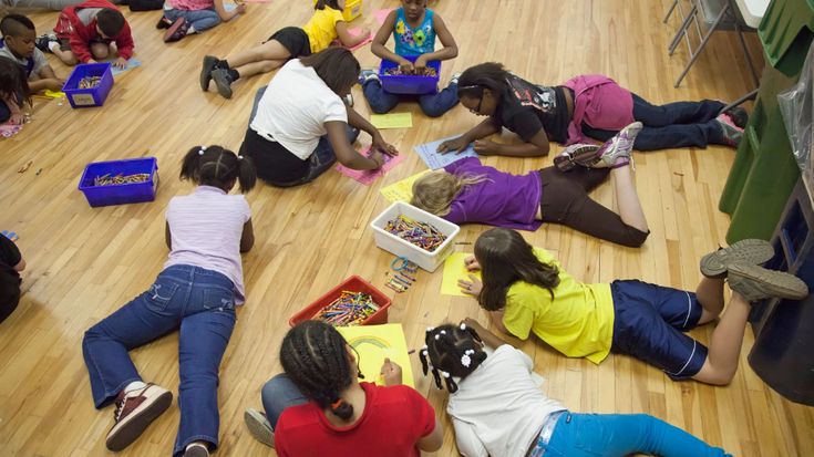 a group of children sitting on the floor in a circle