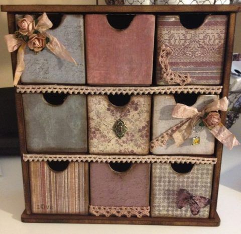 an old drawer with many different colored papers and bows on the top, sitting on a table