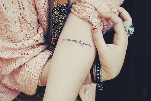 a woman with a tattoo on her arm and the word love is written in cursive writing