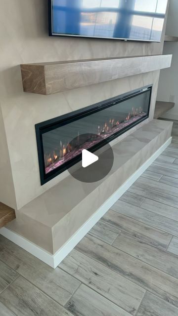 a flat screen tv mounted to the side of a wall next to a fire place