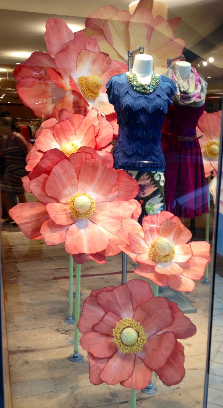 two screenshots of mannequins with flowers on display in store windows