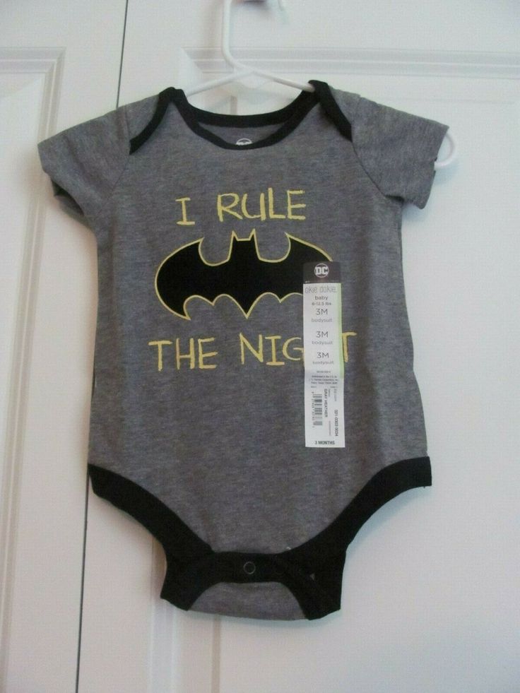 OKIE DOKIE BABY BOY'S BATMAN SHORT SLEEVE ONE-PIECE THE FRONT OF THE ONE-PIECE HAS "I RULE THE NIGHT" IN YELLOW PRINT  IN THE MIDDLE OF THE SAYING IS THE BATMAN LOGO IN BLACK WITH YELLOW TRIM THE ONE-PIECE IS DARK GRAY WITH BLACK TRIM THE BOTTOM HAS A 3 SNAP CLOSURE THE ONE-PIECE IS A LITTLE WRINKLED FROM BEING FOLDED AND STORED SIZE: 3 MO. ( 8 - 12-1/2 LBS) MATERIAL: 60% COTTON / 40% POLYESTER "TURN INSIDE OUT.  MACHINE WASH COLD WITH LIKE COLORS.  GENTLE CYCLE.  ONLY NON-CHLORINE BLEACH WHEN N Fitted Short Sleeve Bodysuit With Cartoon Print, Short Sleeve Character Print Bodysuit For Playtime, Short Sleeve Bodysuit With Character Print For Playtime, Fitted Short Sleeve Cartoon Print Bodysuit, Cotton Short Sleeve Onesie For Bedtime, Cotton Short Sleeve Bodysuit With Character Print, Cotton Bodysuit With Character Print And Short Sleeves, Fitted Cartoon Print Onesie With Short Sleeves, Fitted Character Print Onesie With Short Sleeves