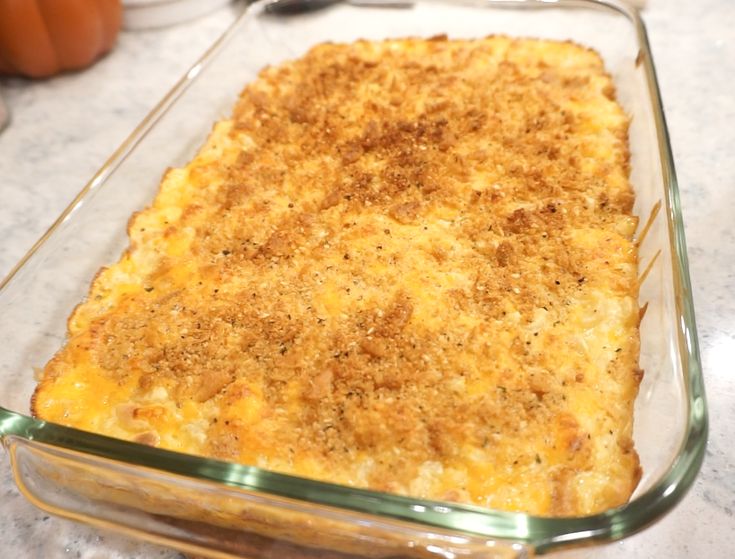 a casserole dish with cheese and seasoning in it sitting on a counter