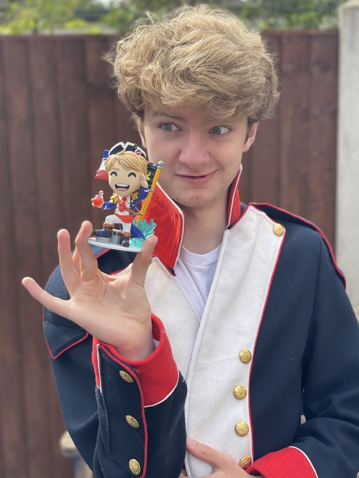 a young man in uniform holding up a toy