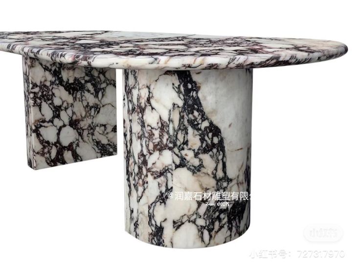 an oval marble table with black and white veining on the top, against a white background