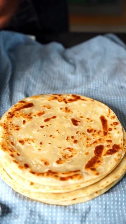 a stack of flat bread on top of a blue towel