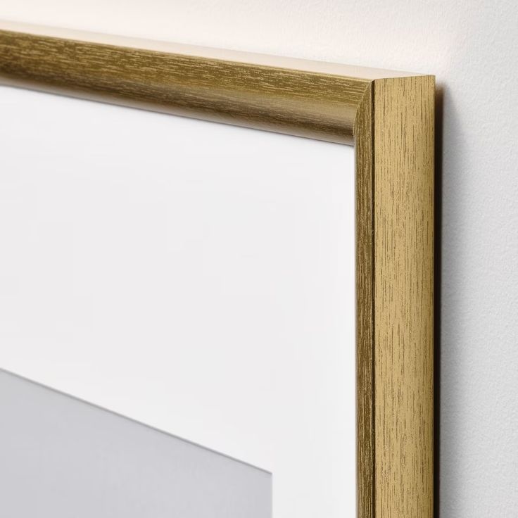 a white wall with a wooden frame hanging on it