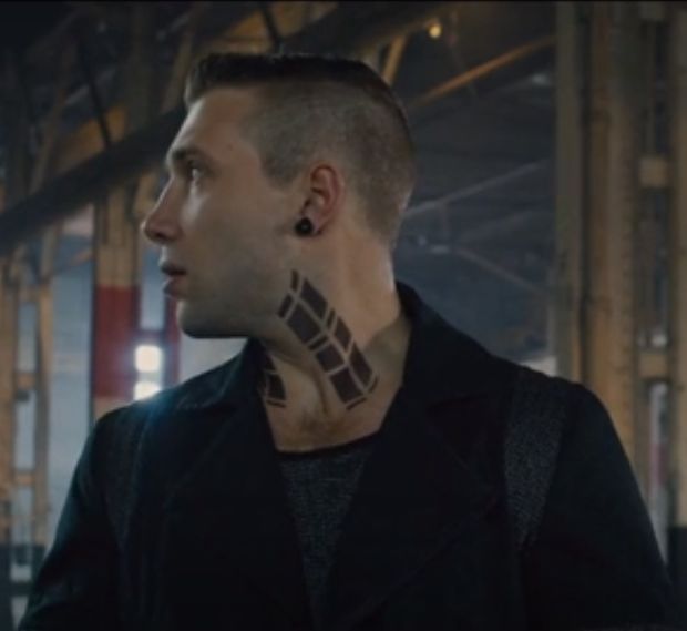 a man with tattoos on his face and neck