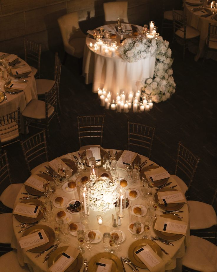 an overhead view of a table set for a formal dinner with candles and flowers on it