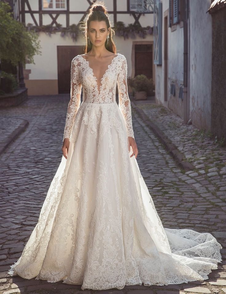 a woman in a wedding dress standing on a cobblestone street