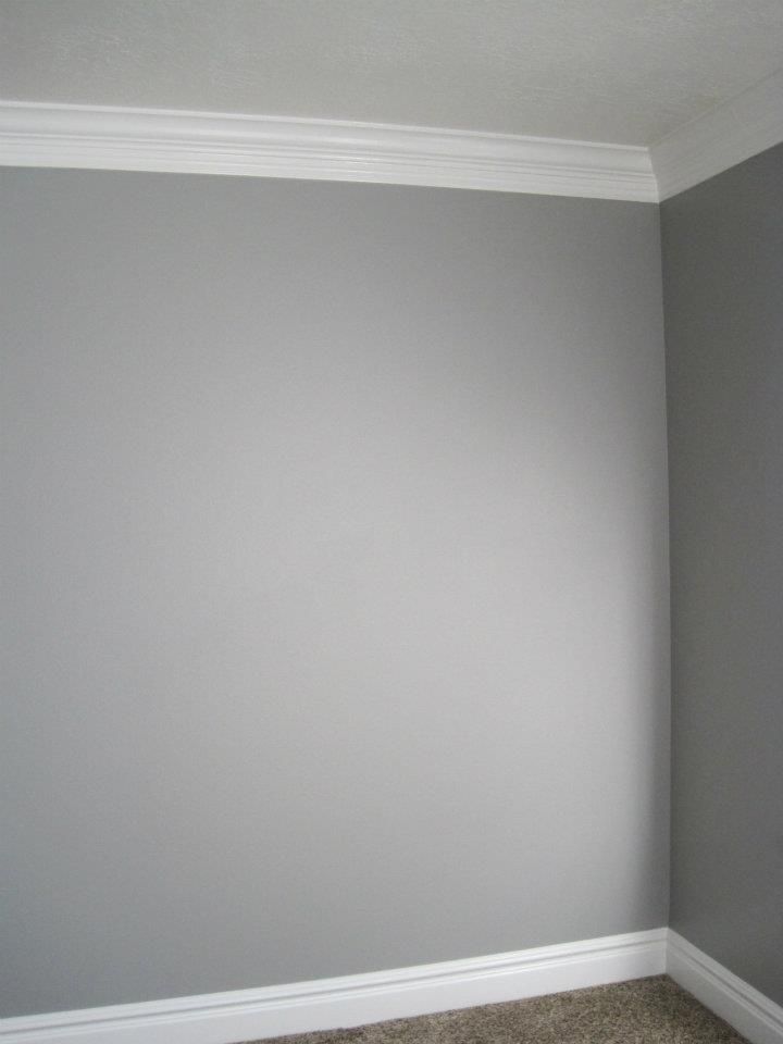 an empty room with gray walls and carpet