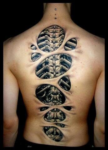 the back of a man's neck with an intricate tattoo design on his chest