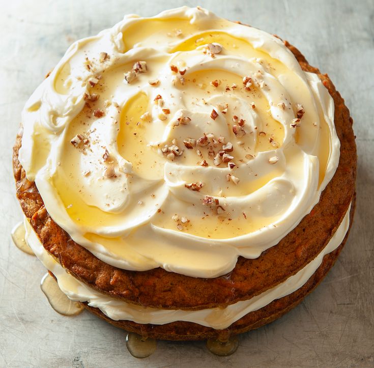 a cake with white frosting and nuts on top