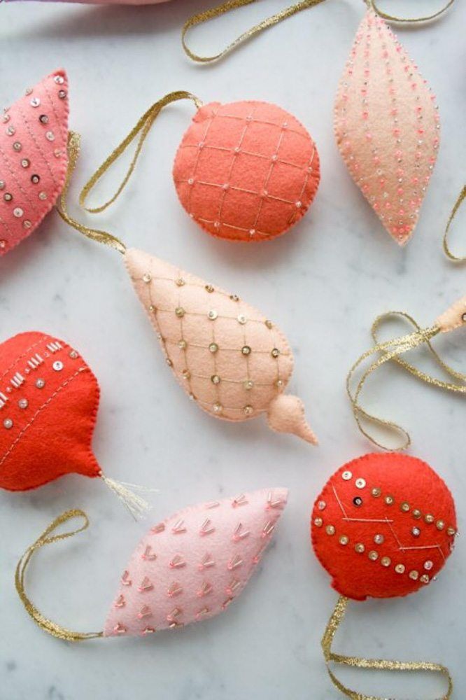 some ornaments are sitting on a table with gold trimmings and pink, red, and peach colors