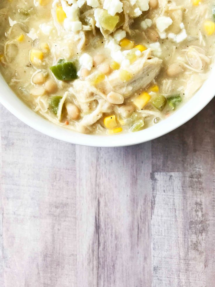 a bowl of chicken noodle soup on a wooden table