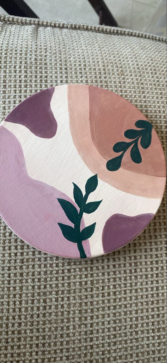 a pink and green plate sitting on top of a couch