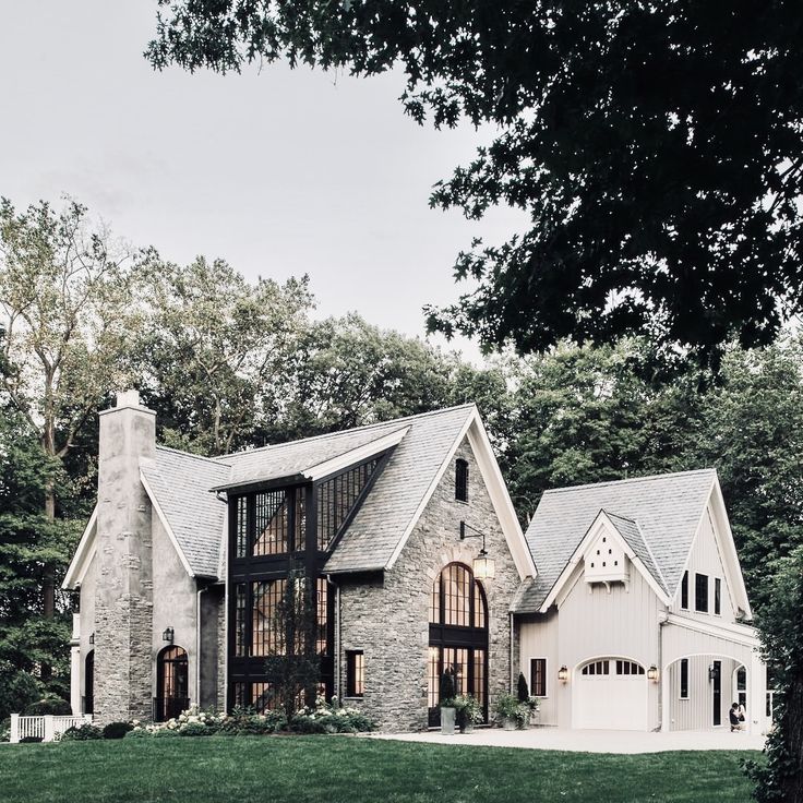 a large house in the middle of a lush green field with trees and grass around it