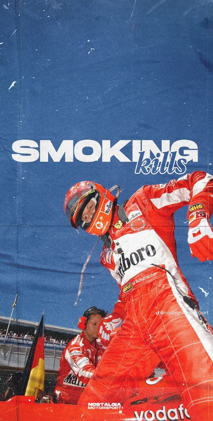 a man standing on top of a red race car in front of a blue banner