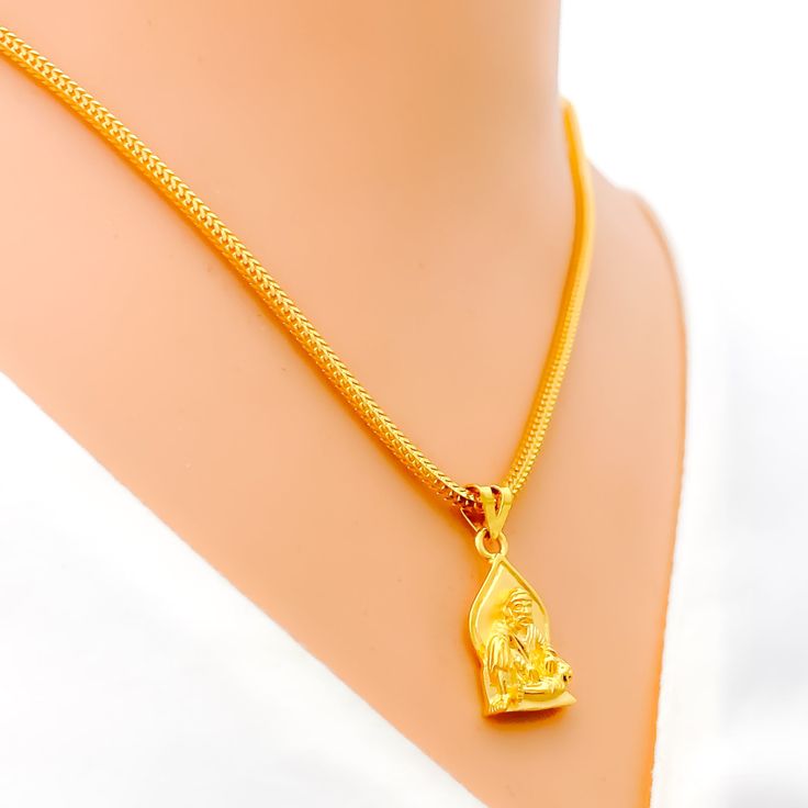 This attractive pendant, exquisitely crafted from 22k gold and weighing 3.2 grams, features a finely engraved depiction of Sai Baba set against a luminous yellow gold finish. The pendant has a length of 0.9 inches, making it both noticeable and modest in size, ideal for daily wear. Perfect for devotees who wish to keep Sai Baba close to their hearts, this pendant combines spiritual devotion with elegant craftsmanship, offering a timeless piece that embodies grace and serenity. PRODUCT DETAILS Gold Purity(karat): 22k Gold Weight(grams): 3.2 Item Finish: Yellow Gold Pendant Length: 0.9" Chain: Not Included 22k Gold Amulet Necklace For Ceremonial Occasions, 22k Gold Ceremonial Amulet Necklaces, 22k Gold Amulet Necklaces For Ceremonial Occasions, 22k Gold Amulet Necklace For Ceremonial Use, 22k Gold Hallmarked Temple Necklace Pendant, Gold Plated Gold Necklace For Puja, 22k Gold Necklaces For Puja, Traditional Yellow Gold Temple Necklace As Gift, Yellow Gold Temple Necklace With Locket For Festivals