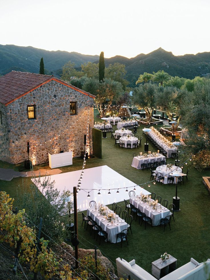 an outdoor dining area with tables and chairs set up for formal function in the evening