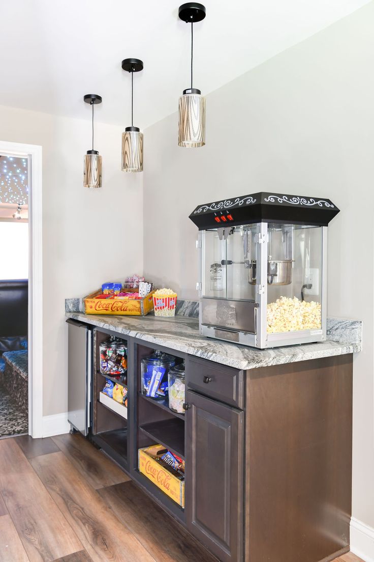 a breakfast bar with popcorn, drinks and snacks on the counter in front of it