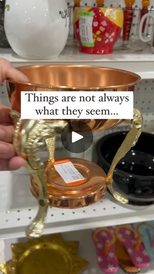 a person is holding a cup in front of shelves with other items on it and a sign that says things are not always what they seem