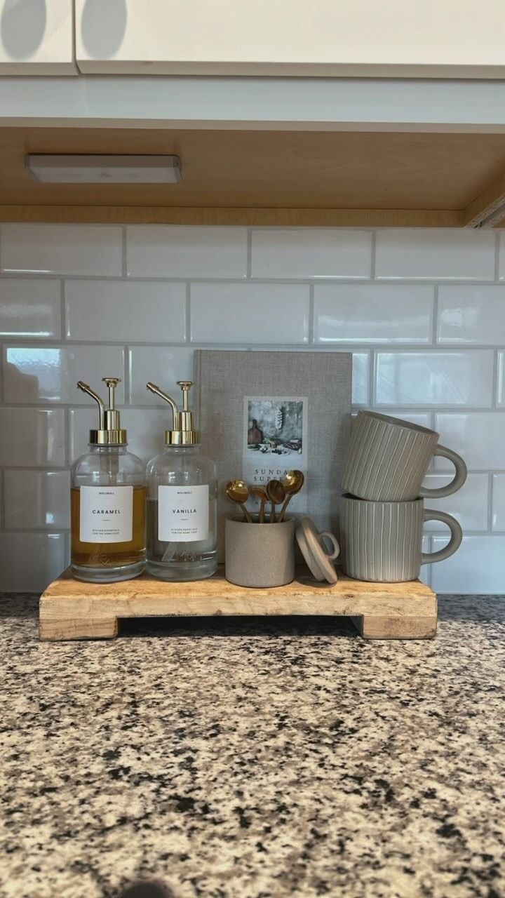 a kitchen counter with soap, toothbrushes and other items on top of it