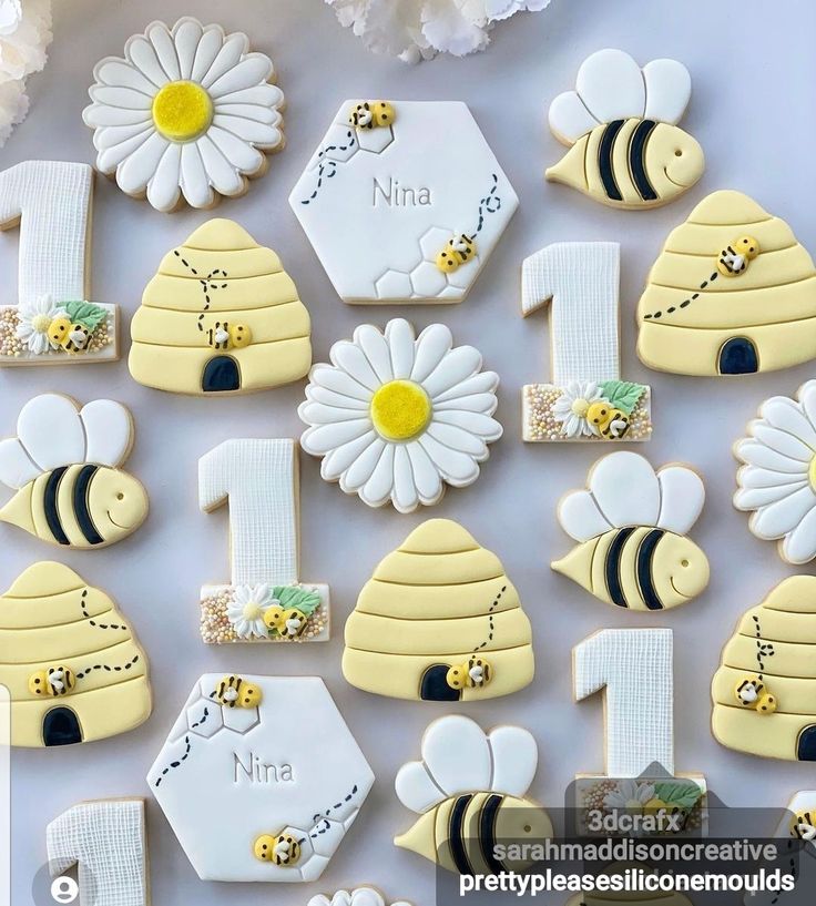 decorated cookies are arranged in the shape of numbers and bees with daisies on them