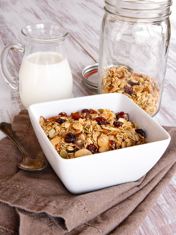 a bowl of granola next to a glass of milk