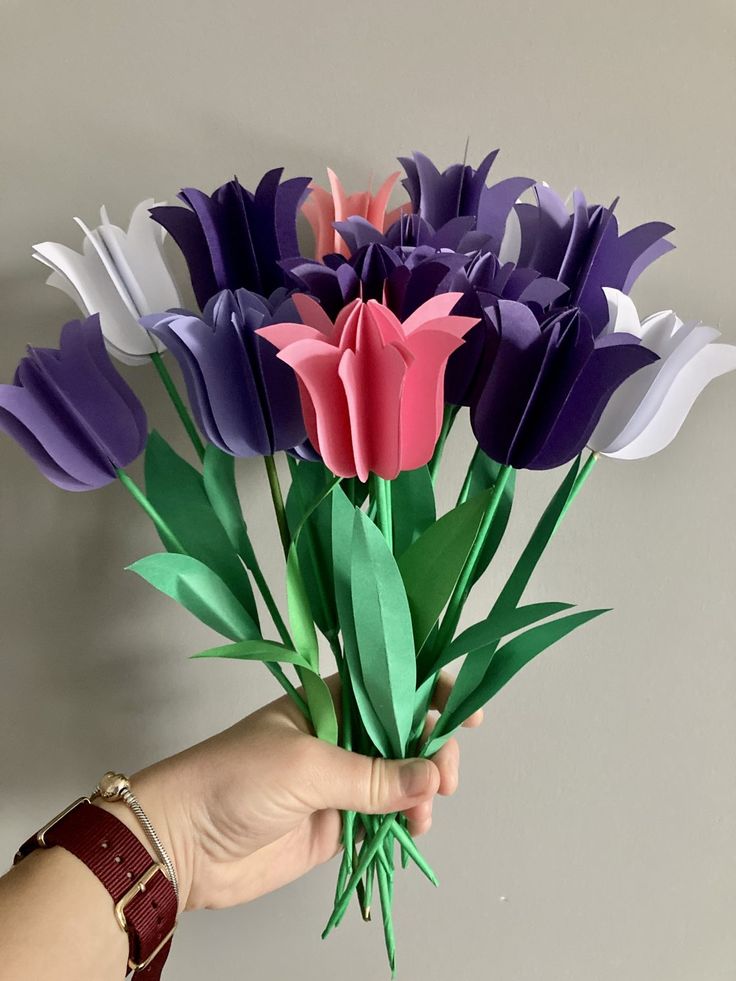 a person is holding some paper flowers in their hand