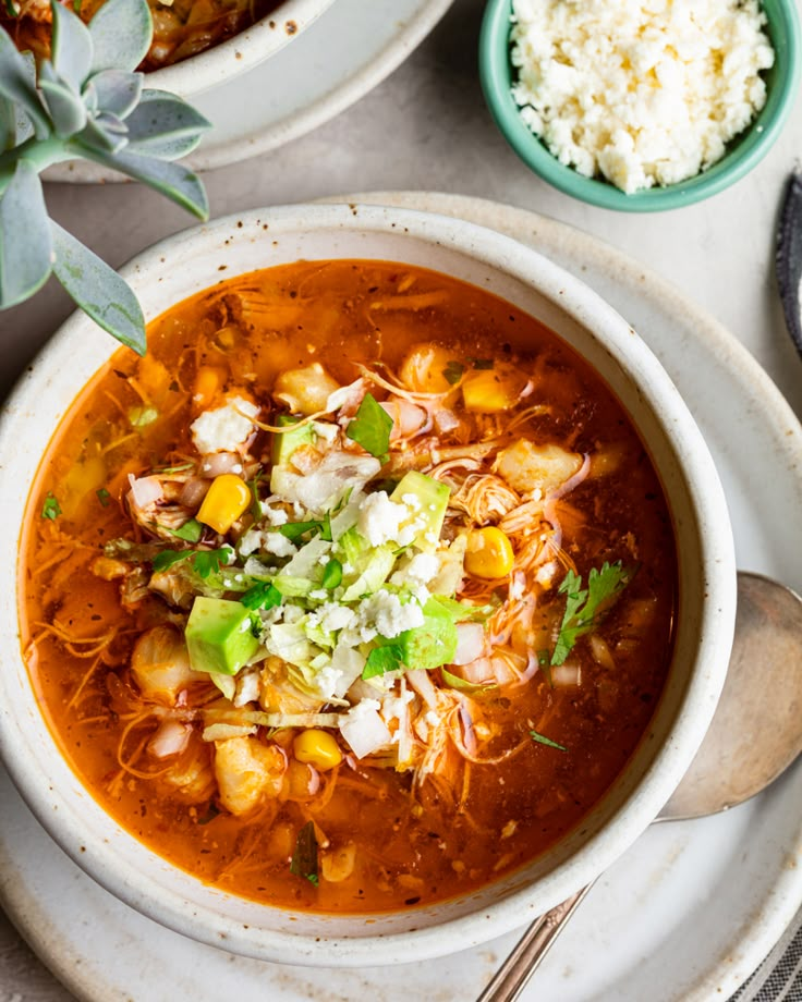 two bowls filled with soup and rice on top of a table