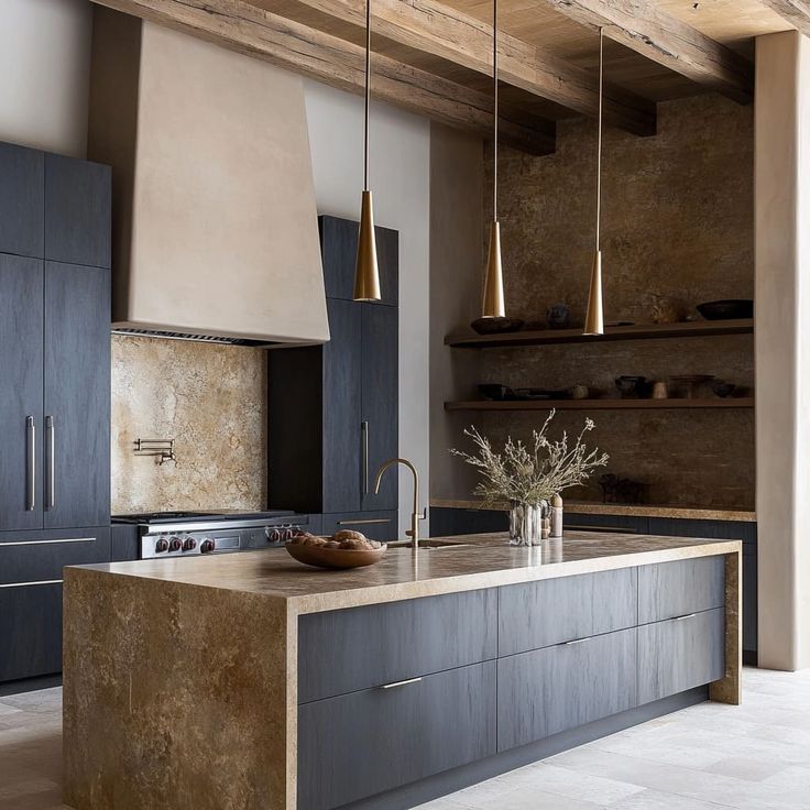 a large kitchen with an island in the middle and two lights hanging from the ceiling