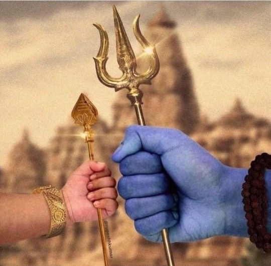 two people holding hands with gold and blue paint on their body, one is holding a golden stick