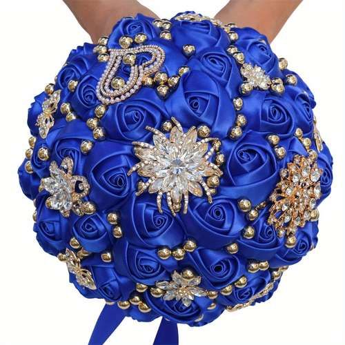 a bridal bouquet with blue roses and brooches on the bottom is being held by someone's hand