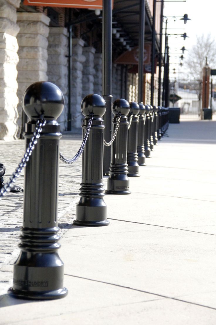 a row of black poles sitting on the side of a street