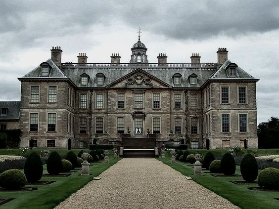 a large stone building with lots of windows on top of it's roof and walkway leading to the front entrance