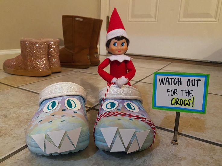 an elf is sitting on top of two crocs with a sign that says watch out for the crocos